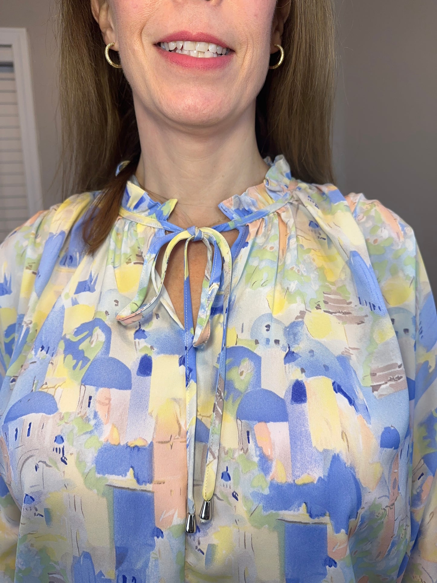 Blue multi printed v-neck 3/4 sleeve top featuring ruffle detail at neck.