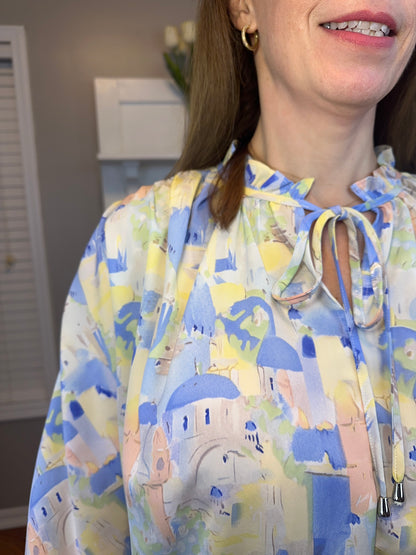 Blue multi printed v-neck 3/4 sleeve top featuring ruffle detail at neck.