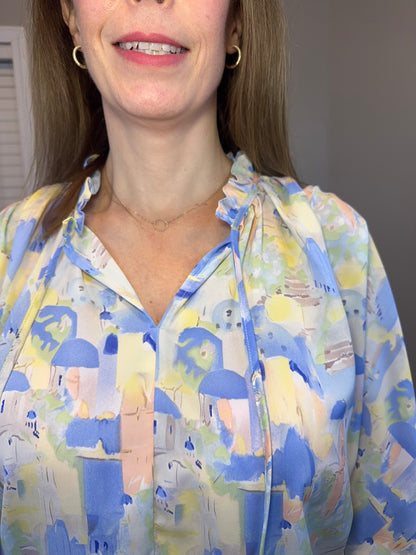 Blue multi printed v-neck 3/4 sleeve top featuring ruffle detail at neck.