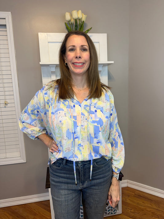 Blue multi printed v-neck 3/4 sleeve top featuring ruffle detail at neck.