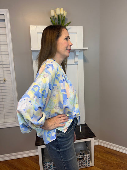 Blue multi printed v-neck 3/4 sleeve top featuring ruffle detail at neck.
