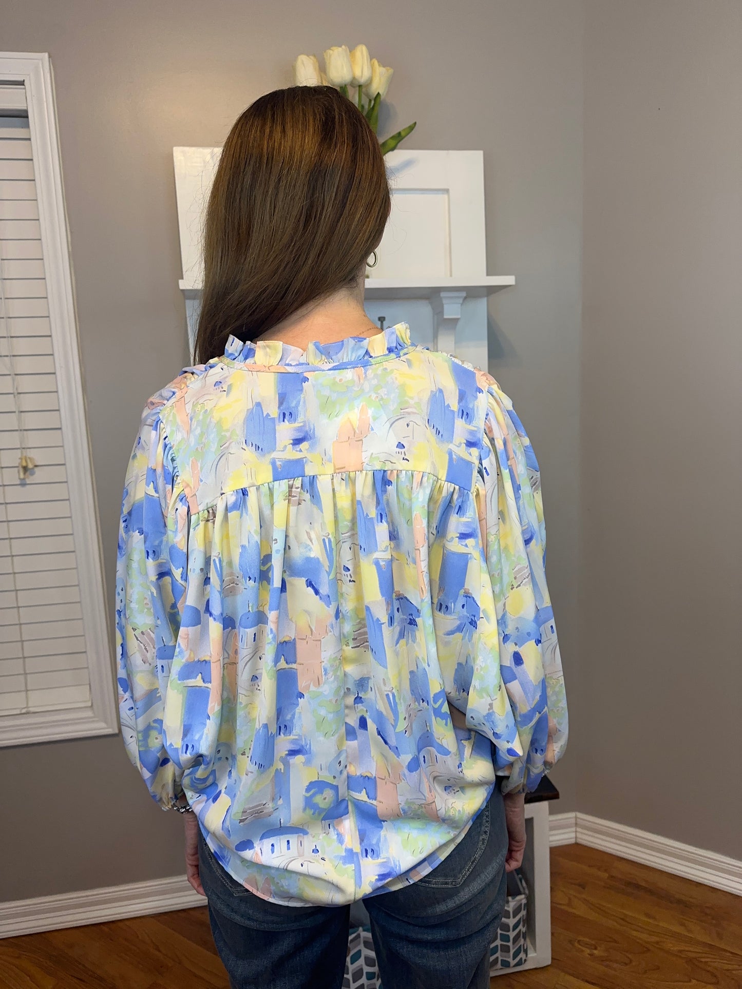 Blue multi printed v-neck 3/4 sleeve top featuring ruffle detail at neck.