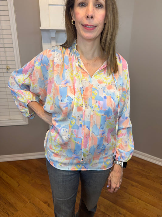 Pink multi printed v-neck 3/4 sleeve top featuring ruffle detail at neck.