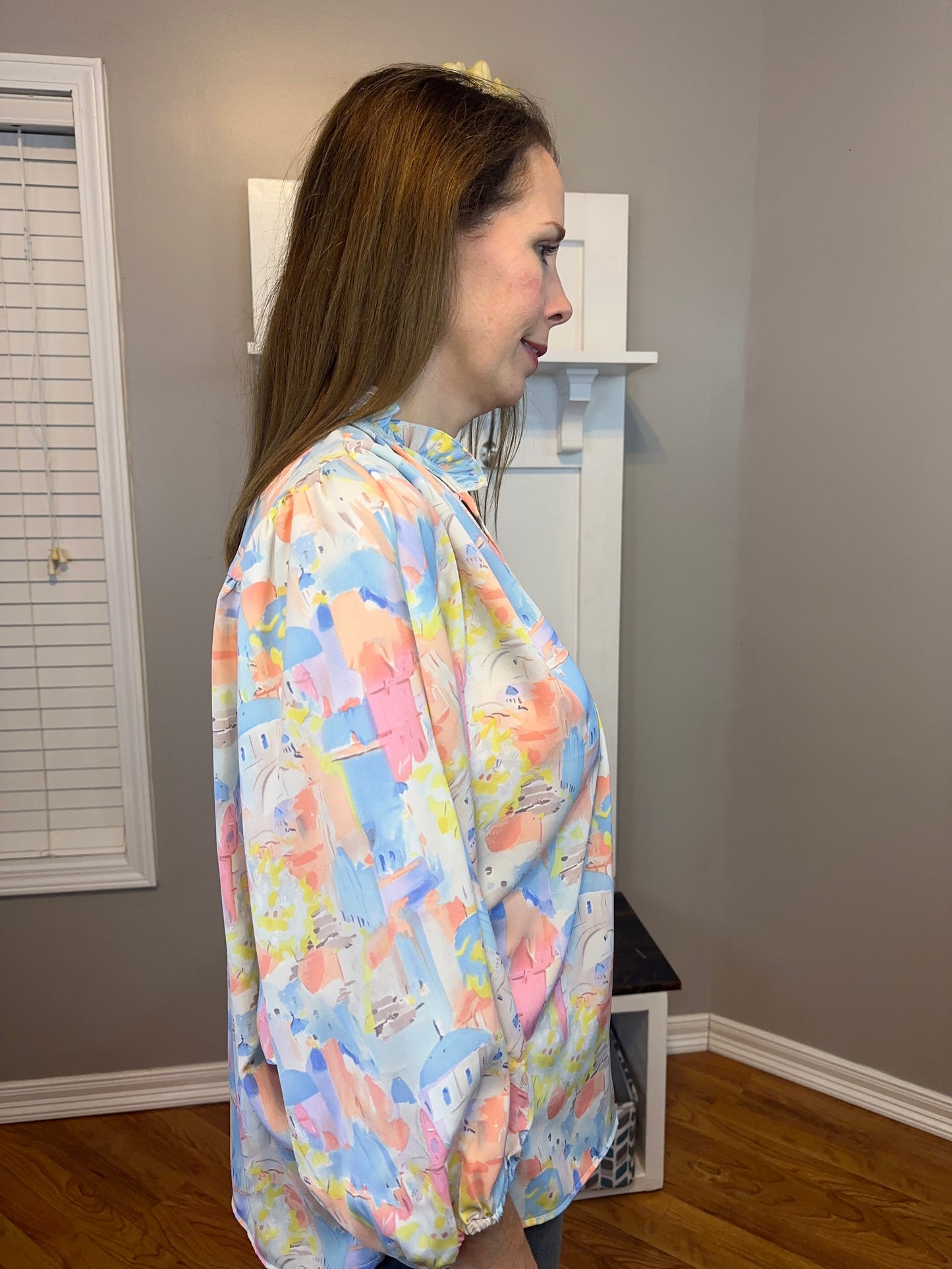 Pink multi printed v-neck 3/4 sleeve top featuring ruffle detail at neck.