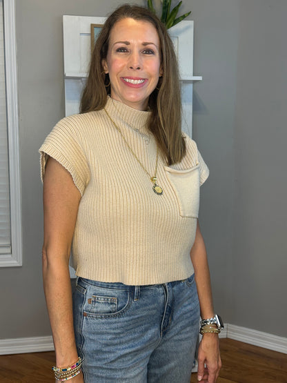 Solid knitted mock neck cropped top featuring single pocket detail.