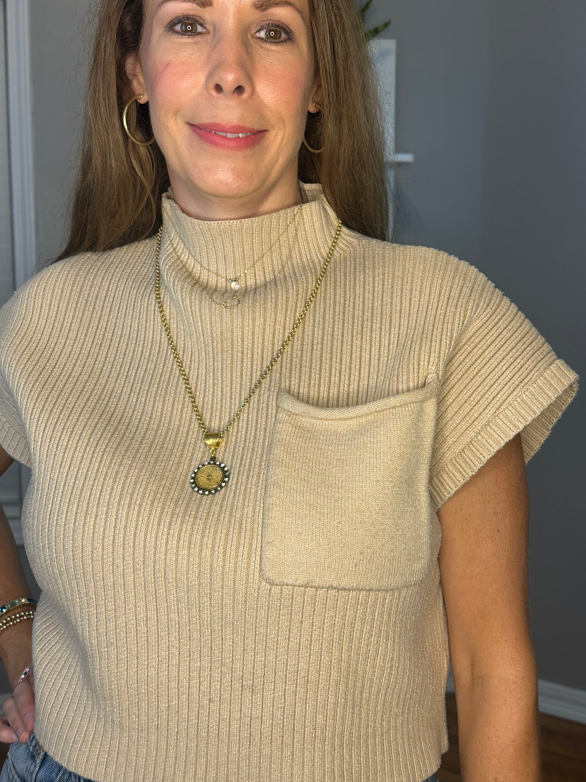 Solid knitted mock neck cropped top featuring single pocket detail.