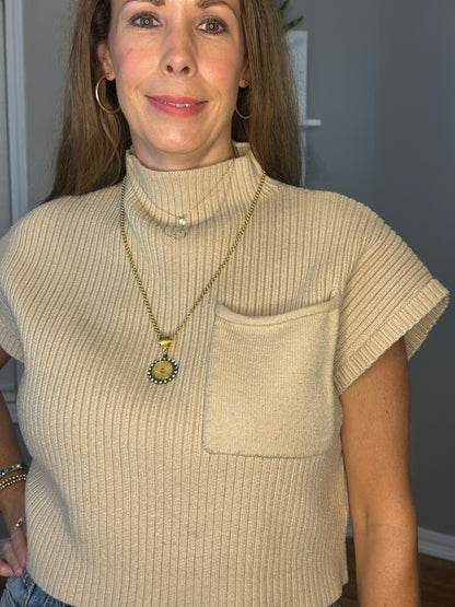 Solid knitted mock neck cropped top featuring single pocket detail.