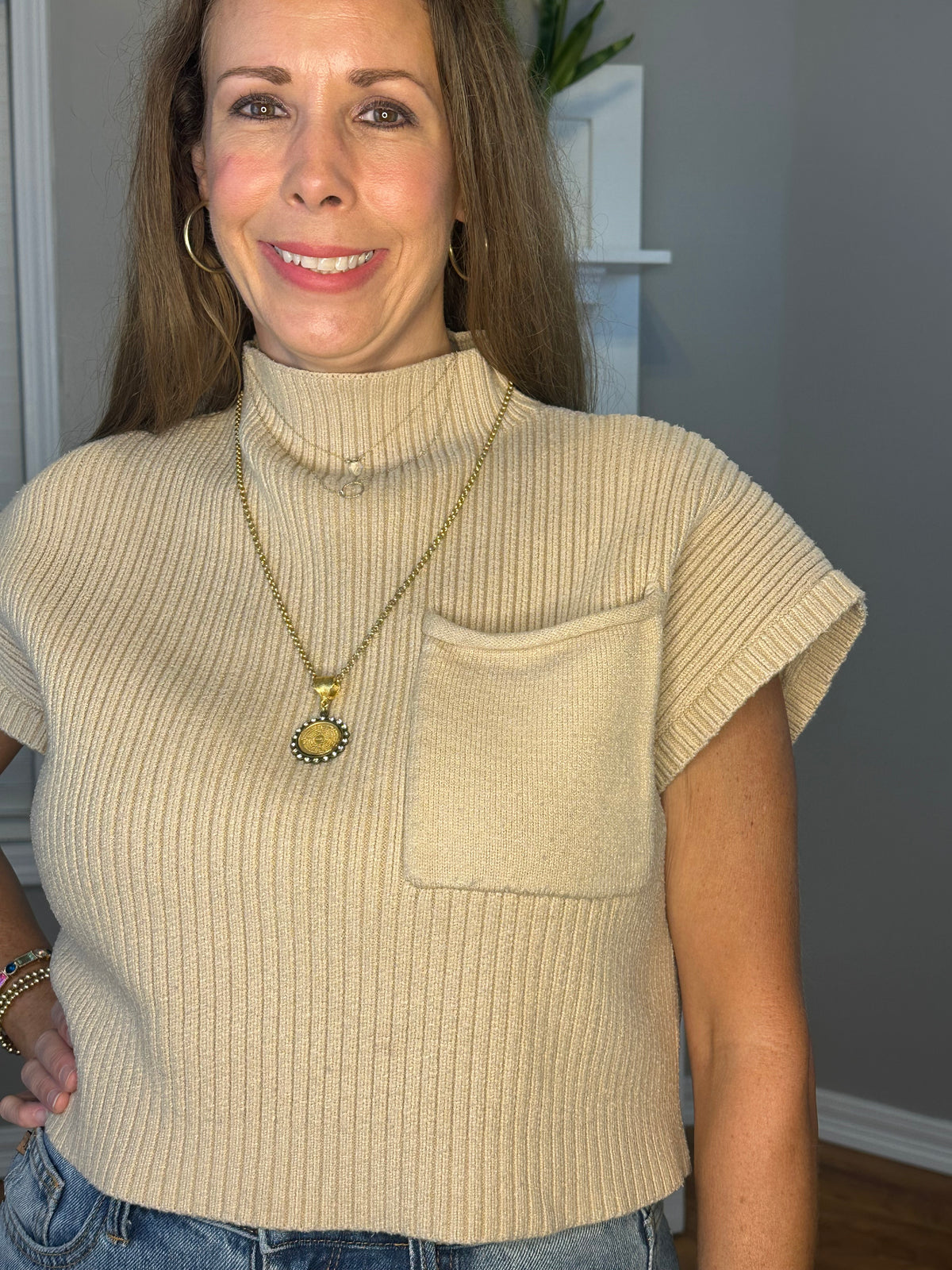 Solid knitted mock neck cropped top featuring single pocket detail.