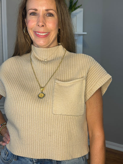 Solid knitted mock neck cropped top featuring single pocket detail.