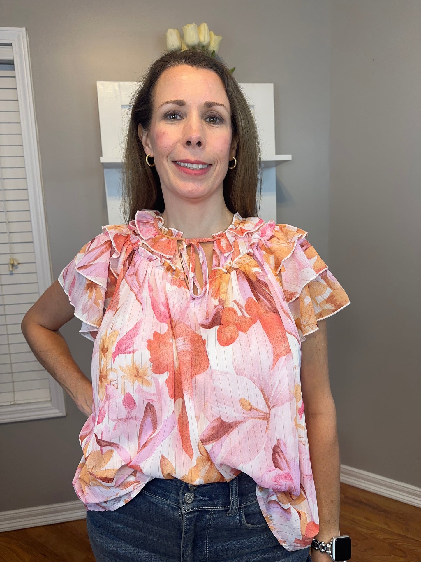 Floral print v-neck ruffle sleeve top featuring self tie at front neck.