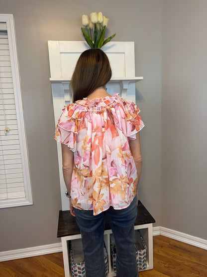 Floral print v-neck ruffle sleeve top featuring self tie at front neck.