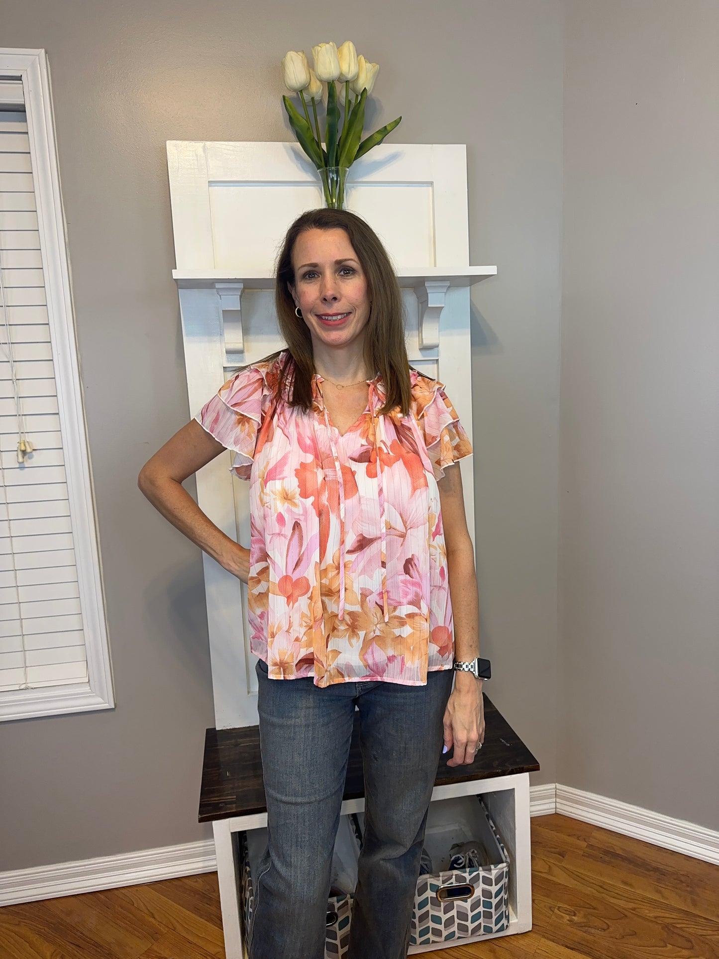 Floral print v-neck ruffle sleeve top featuring self tie at front neck.