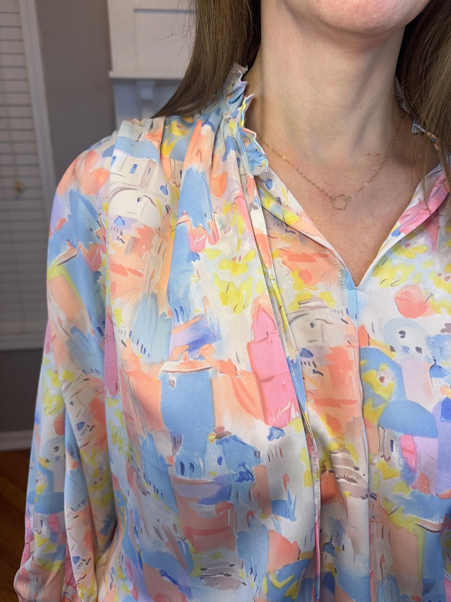 Pink multi printed v-neck 3/4 sleeve top featuring ruffle detail at neck.