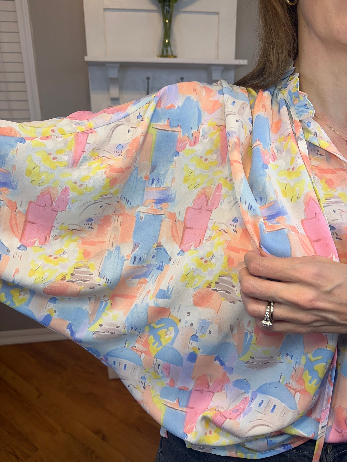 Pink multi printed v-neck 3/4 sleeve top featuring ruffle detail at neck.