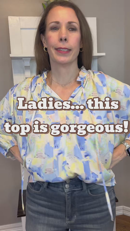Blue multi printed v-neck 3/4 sleeve top featuring ruffle detail at neck.